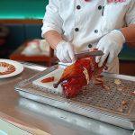 Cocinero sirviendo el pato laqueado en Nankín