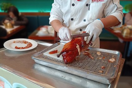 Cocinero sirviendo el pato laqueado en Nankín